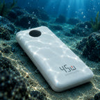 A white portable power bank with '45W 20000mAh' printed on the back, resting on an ocean floor with sunbeams filtering through the water above it.